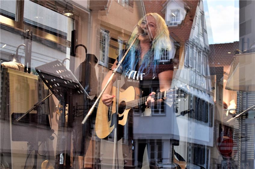 Hygienemäßig nicht zu beanstanden: Sängerin beim „Tübinger Feierabend“ hinter einer Fensterscheibe. Bild: Andrea Bachmann
