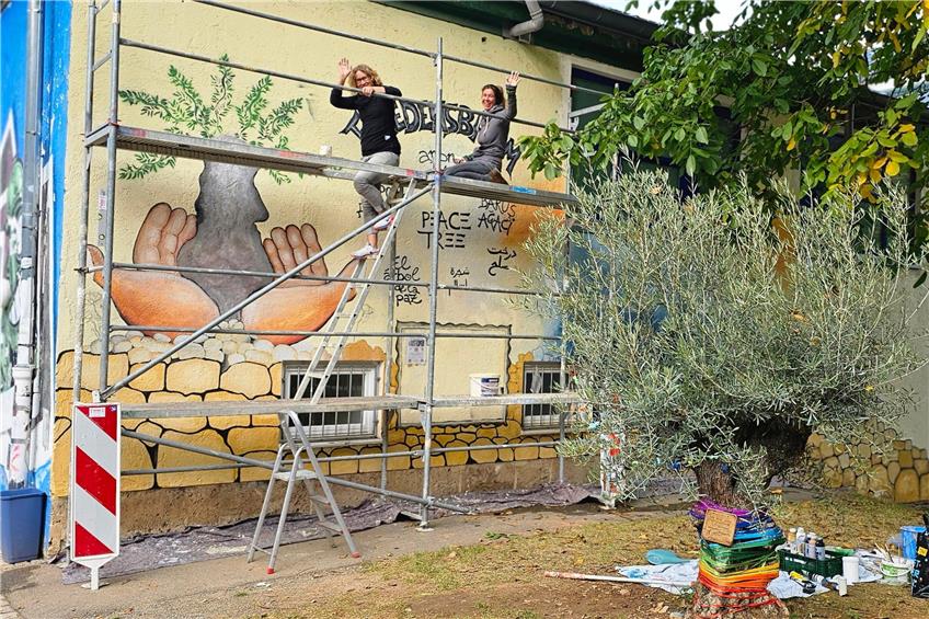 Maria Bauer (links) und Irina Rother haben die Wand neben dem Tübinger Friedensbaum im Französischen Viertel künstlerisch gestaltet. Bild: Fabian Betz